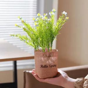 Close-up detail of artificial green plant in a burlap pot with bow decor for home display.