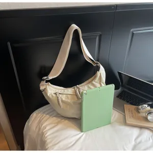 Detailed view of casual nylon crossbody dumpling bag in beige, featuring adjustable strap.