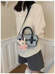 Vista detallada del elegante bolso de hombro texturizado con bonito peluche de conejo tejido.