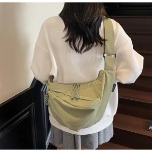 Detailed back view of a light green casual crossbody dumpling bag worn with style.