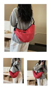 Detailed view of the red plaid nylon slouchy shoulder bag worn by model, casual style.