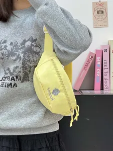Detailed view of the yellow canvas fanny pack featuring cute bear embroidery and zipper.