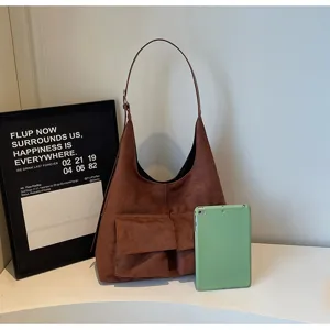 Brown suede shoulder bag with dual front pockets, vintage hobo design for autumn commuting.