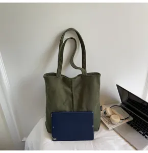 Detailed view of the olive green corduroy tote bag with spacious interior and durable handles.