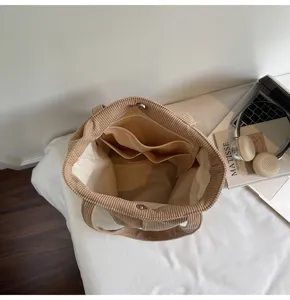 Corduroy tote bag interior detail showing spacious compartment and practical storage pockets.