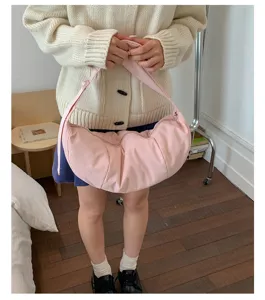 Vista detallada del bolso de hombro rosa de moda en tela suave, exhibición de estilo de vida.