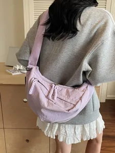 Casual commuter dumpling crossbody bag with wide strap and stylish braided zipper pulls.