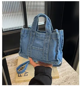 Vue détaillée du sac cabas décontracté en denim bleu avec coutures contrastées et anses.
