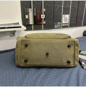 Green canvas travel duffel bag bottom view with protective feet, durable gym storage accessory.