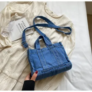 Vue détaillée du sac bandoulière en denim rétro, grande capacité et tissu résistant.