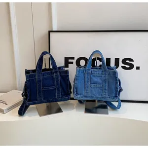 Vue détaillée des sacs en jean sur supports, montrant la texture et le design fonctionnel.