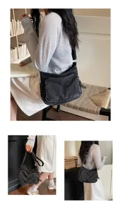 Dettaglio della borsa a tracolla in denim lavato con design casual per il lavoro quotidiano.