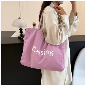 Vista detallada de un bolso tote de nailon impermeable morado con estampado Blessing, chic.