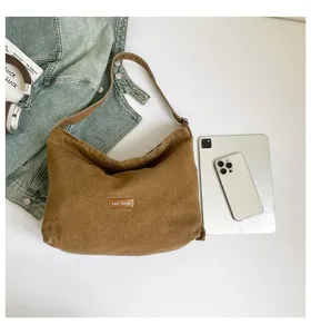 Bolso de hombro de lona marrón con estilo casual, ideal para el uso diario y looks modernos.