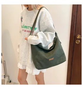 Bolso de lona verde informal llevado por modelo, gran capacidad para uso diario.