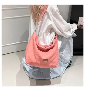 Bolso bandolera de lona rosa vista detallada, diseño retro informal de gran capacidad.