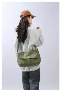 Casual canvas messenger bag detail shot, vintage washed green crossbody bag with snap closure.