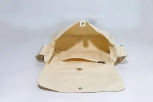 Detailed view of the open beige canvas messenger bag interior, showing zipper pocket and snap button.