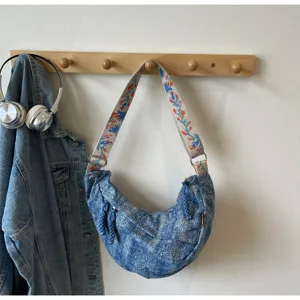 Casual denim crescent shoulder bag with embroidered strap, stylish street style crossbody.