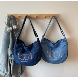 Detail view of vintage denim shoulder bag, casual large capacity commuter crossbody tote style.