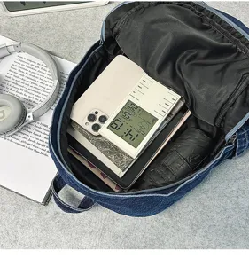 Detailed view of the denim backpack interior, showing large storage capacity and organized use.