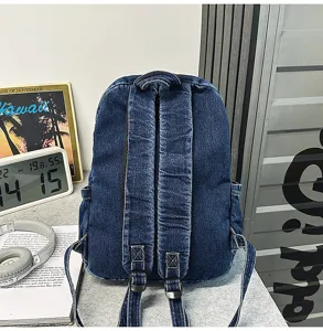 Detailed view of the dark blue denim backpack showing sturdy adjustable shoulder straps.