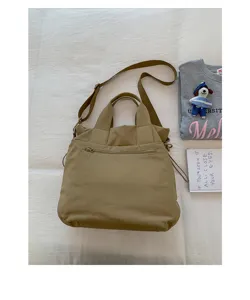 Detail shot of khaki casual commuter tote bag with shoulder strap and front zipper pocket.