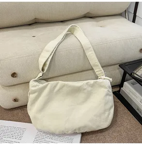 Vista dettagliata della borsa a spalla in tela, consistenza morbida e stile casual quotidiano.