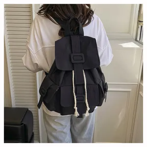 Vista detallada de la mochila casual de lona negra con múltiples bolsillos y hebilla.