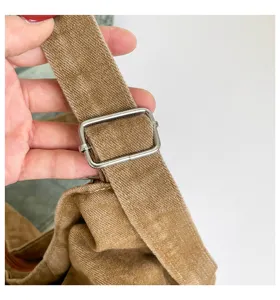 Primer plano de la correa de lona del bolso con hebilla metálica ajustable, elegante.