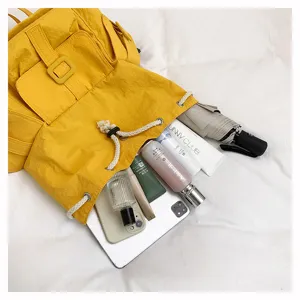 Elegante mochila casual de nylon amarillo con gran capacidad para viajes y uso diario.