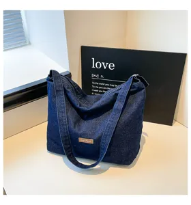Vista detallada del elegante bolso de hombro de mezclilla azul oscuro con diseño retro.