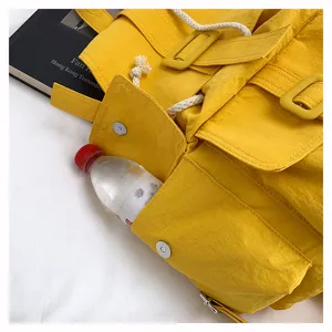 Mochila amarilla detalle de bolsillo lateral, bolso escolar de lona para cercanías.