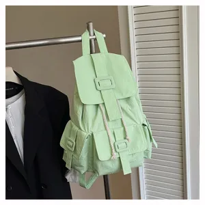 Mochila de lona verde claro informal con múltiples bolsillos y detalles de hebillas.