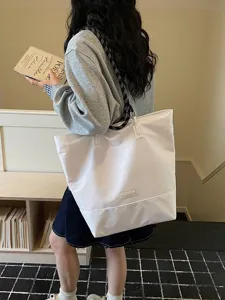 Bolso tote de lona de gran capacidad con correa de contraste, ideal para estudio y trabajo.