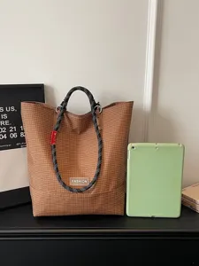 Elegante bolso tote marrón de rejilla con asas de cuerda negra, gran capacidad para uso diario.
