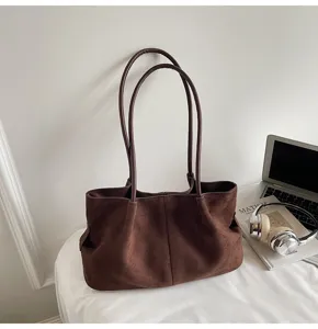 Detail shot of the vintage brown suede tote bag, showcasing large capacity and elegant underarm fit.
