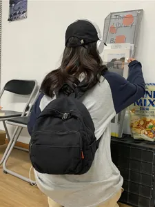 Minimalist black canvas backpack for women and men, casual daily small daypack campus style.