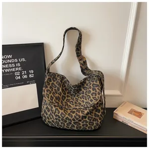 Detallada vista del elegante bolso de hombro de lona con hermoso estampado de leopardo.