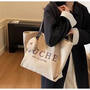 Casual canvas tote bag with coin pouch, large capacity shoulder bag for daily commuting and travel.
