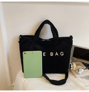Black corduroy shoulder bag detail, casual large capacity handbag with white embroidered letters.