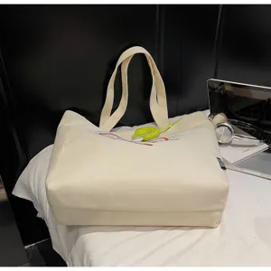 Λεπτομερής όψη τσάντας shopper από καμβά, μεγάλη κεντημένη τσάντα ώμου για καθημερινή χρήση.