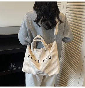 Corduroy tote bag detail view, casual shoulder bag with dual handles and adjustable strap.