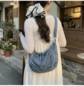Casual denim shoulder bag detail shot showing slouchy design and wide strap for daily commute.