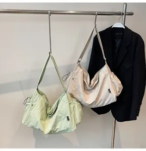 Casual slouchy shoulder bag detail showing large capacity nylon fabric and side drawstring design.