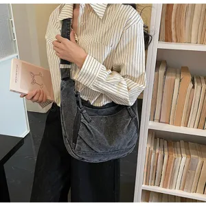 Casual denim shoulder bag detail, featuring soft washed fabric and practical crossbody strap.