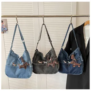 Detailed view of casual denim shoulder bags featuring cute dachshund embroidery and pendants.