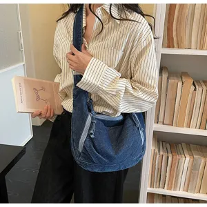 Detail shot of a casual denim shoulder bag, large capacity, perfect for daily commute.