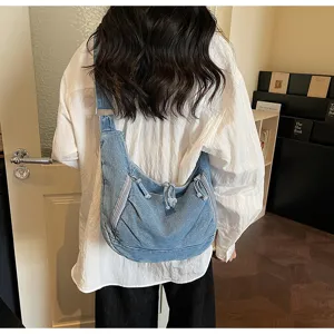 Casual denim shoulder bag shown in detail, featuring large capacity and stylish design.