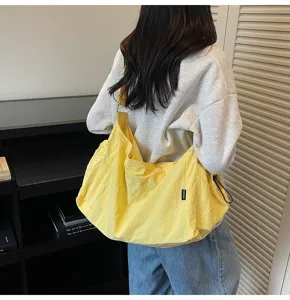 Casual yellow crossbody shoulder bag detail view, showing soft fabric and spacious design.